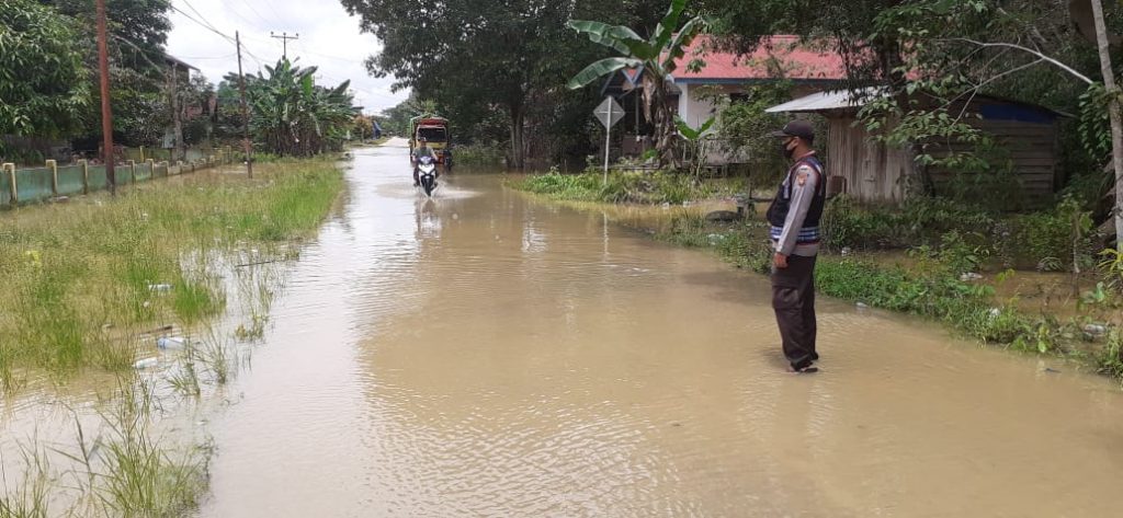 CURAH HUJAN MASIH TINGGI PERSONIL POLSEK SEPAUK PANTAU INGATKAN WARGA AGAR SELALU WASPADA BANJIR
